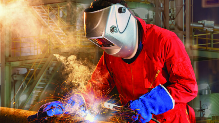 engineer contractor with appropriate safety gear soldiering metal