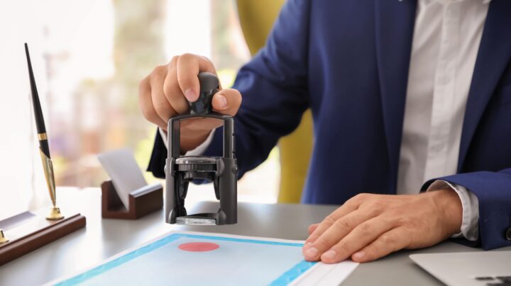 man stamping documents in approval at work - speeding up approval process CHAS