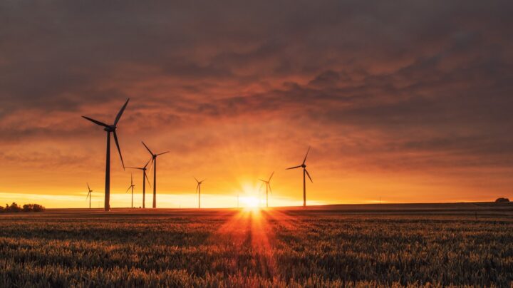 open field of wind turbines and a setting sun. An Environmental Certification scheme is important