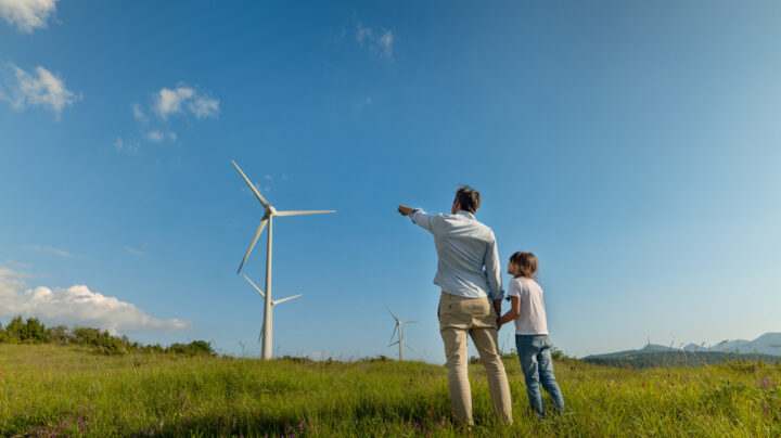 A parent and child looking at a wind turbine on a mountain - a blog about biodiversity legislation