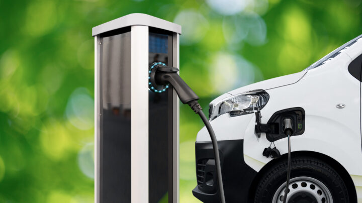 Electric delivery van with charging station on a green background