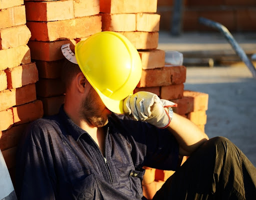 a construction worker sleeping symbolising construction delays