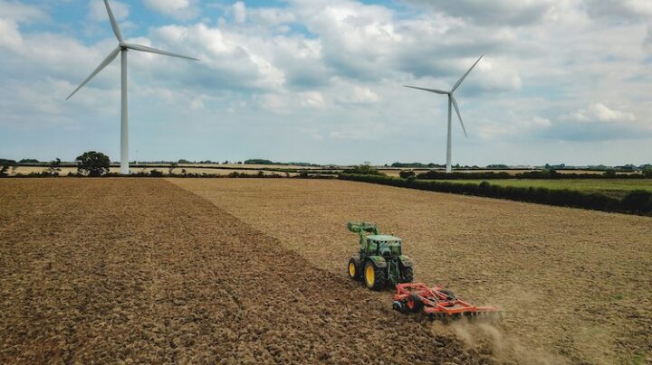 tractor harvesting field during daytime