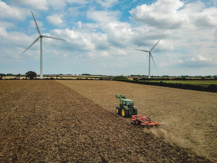 tractor harvesting field during daytime