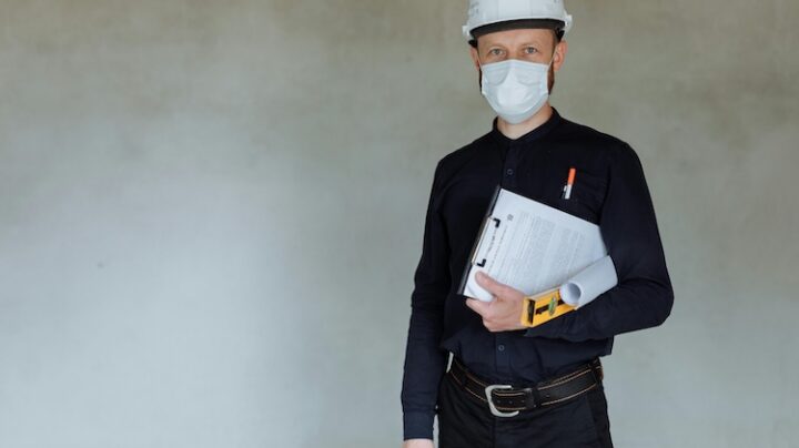 man in business attire wearing safety hard hat
